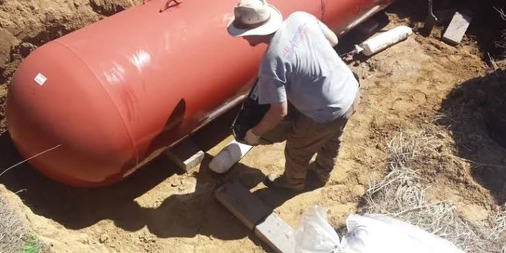 Technician setting an underground propane tank